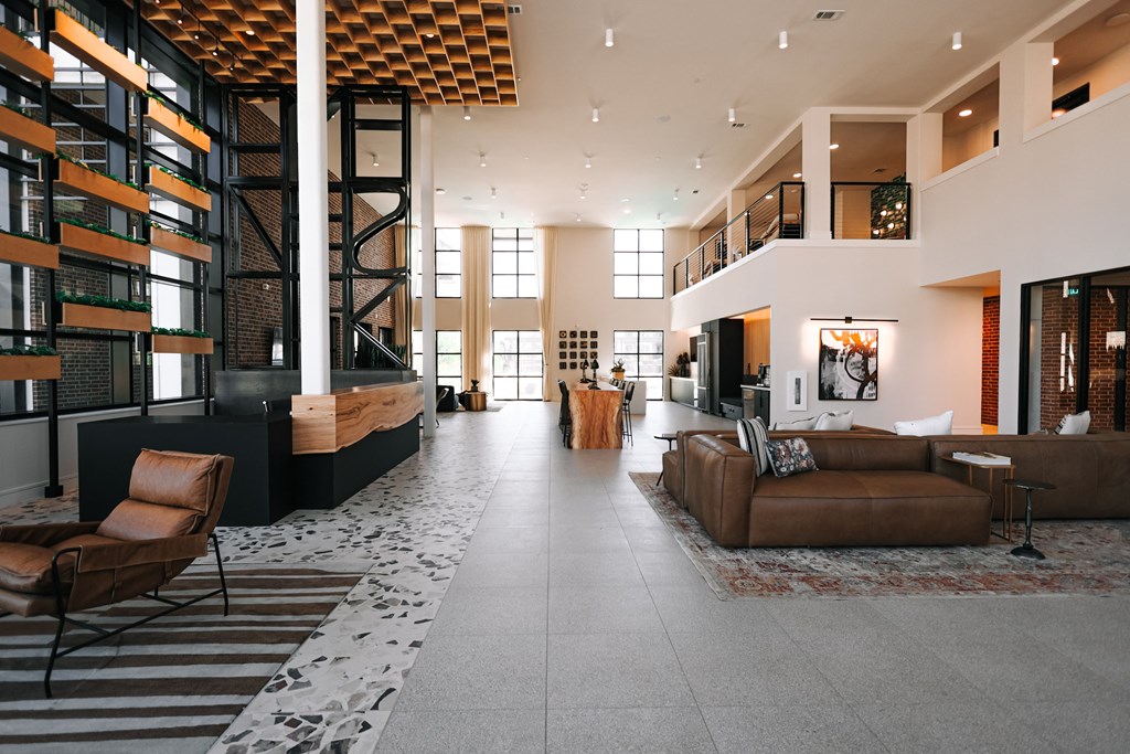 a large living room with couches and chairs and a staircase