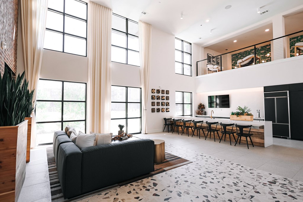 a living room with a black couch and a table with chairs
