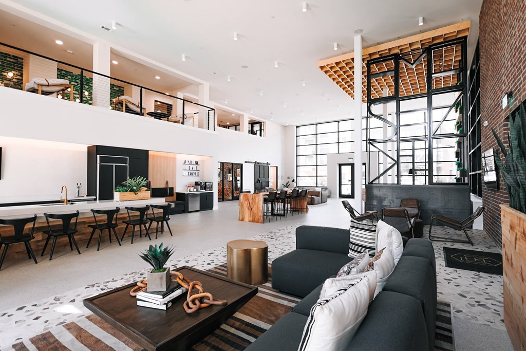 a living room with a black couch and a table with chairs