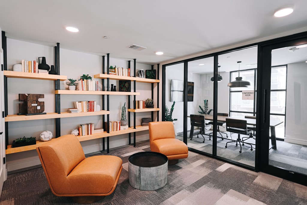 a living room with orange chairs and a table