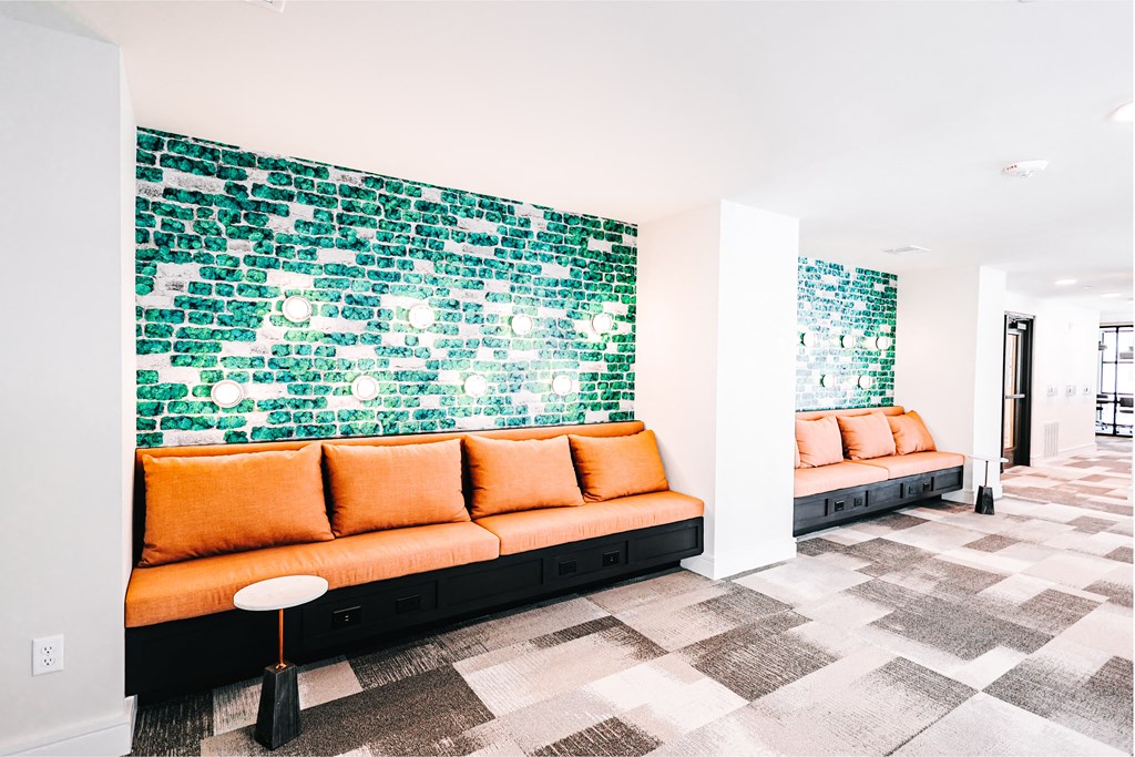 a living room with orange couches and a green wall