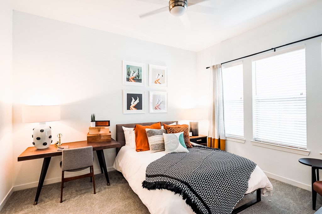 a bedroom with a bed and a desk with a chair