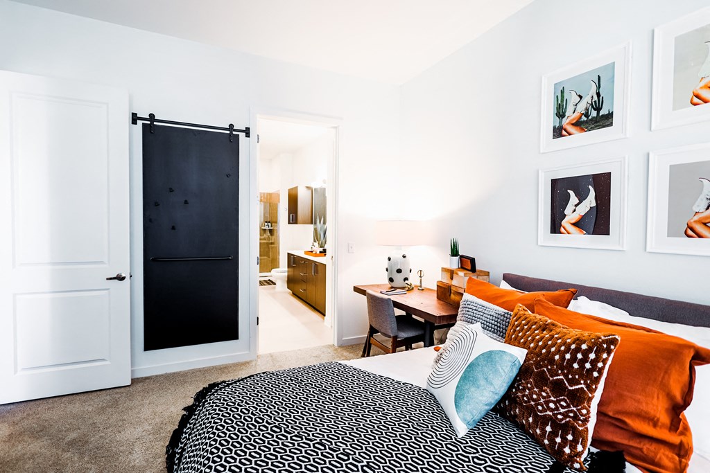 a bedroom with a bed and a desk and a bathroom