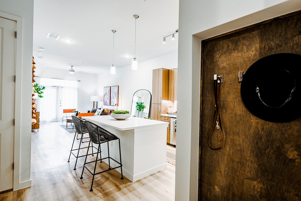 a kitchen and dining room with a white island and bar stools