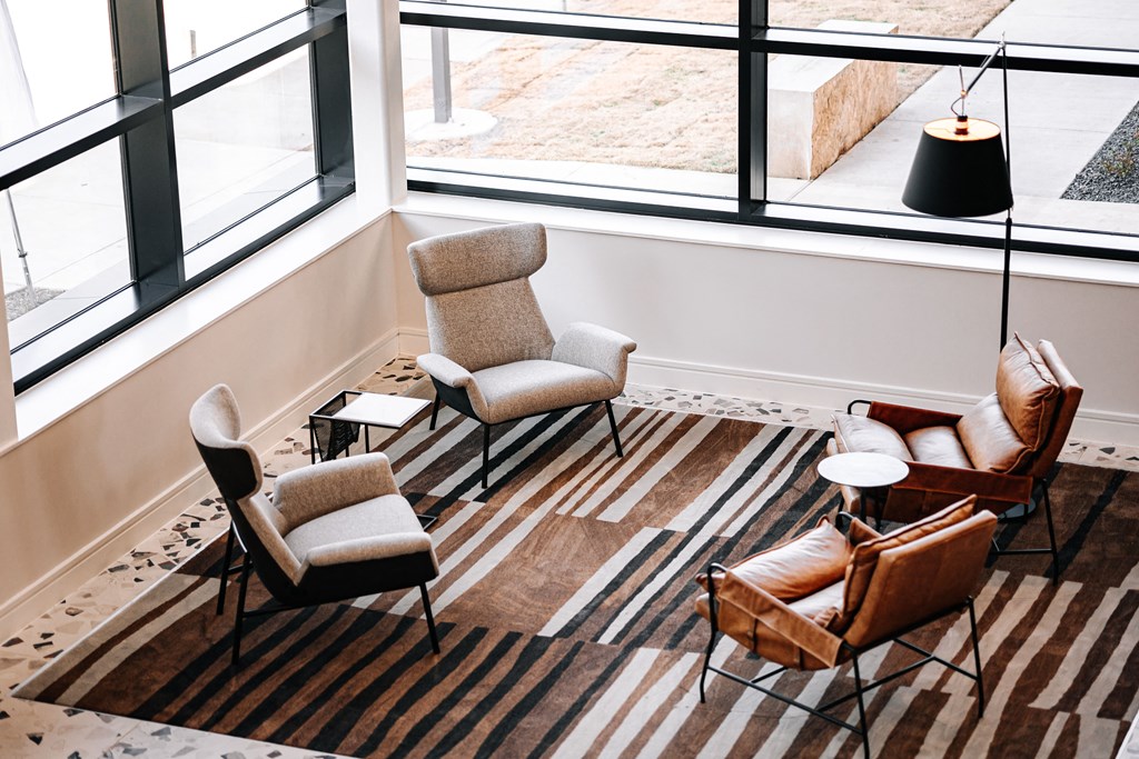 a living room with chairs and a rug