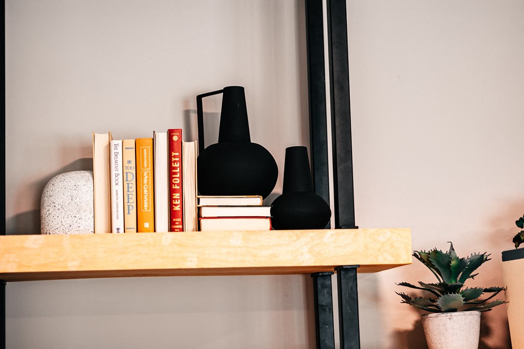 a bookshelf with books and a black lamp on it