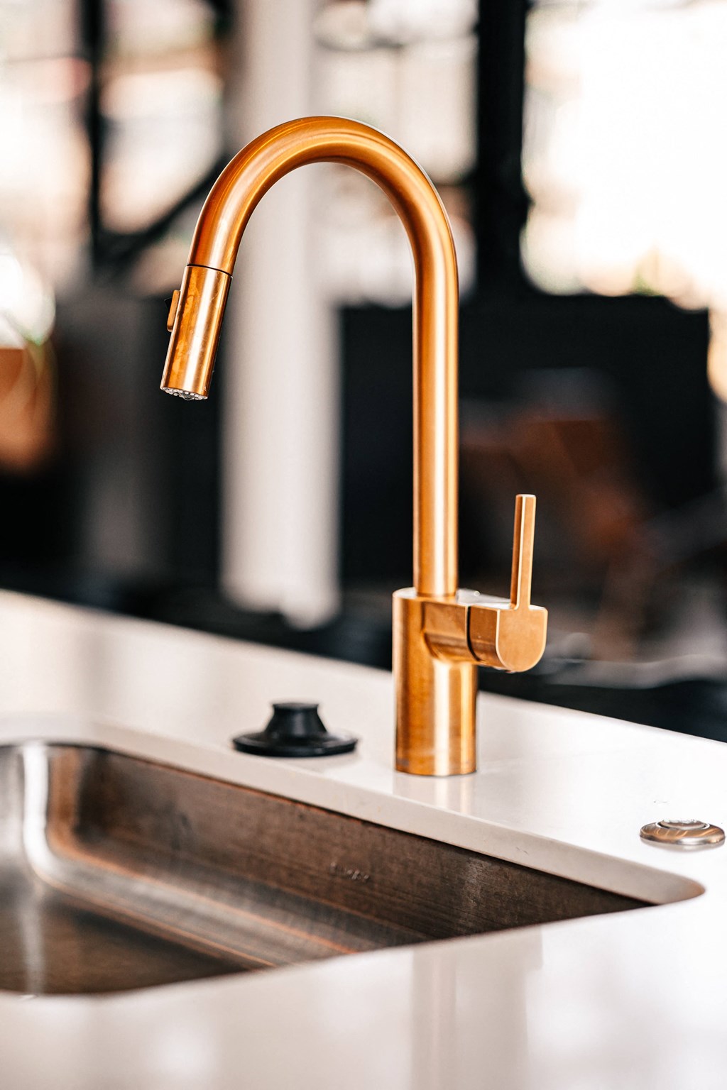 a close up of a gold faucet in a kitchen sink