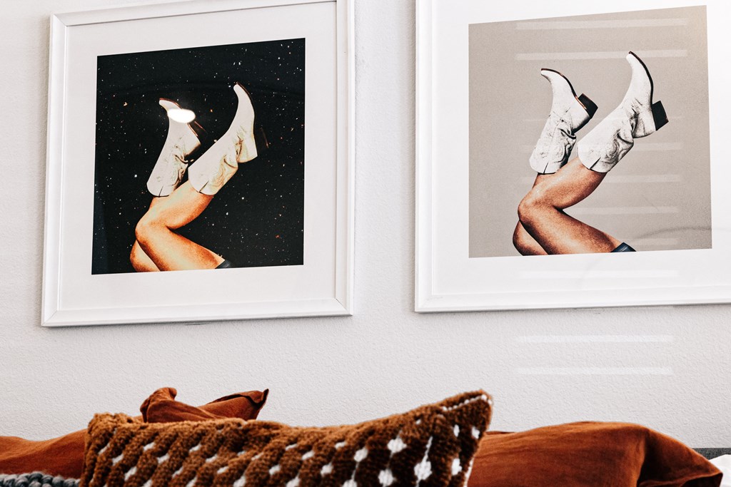 two pictures hanging on a wall next to a couch with pillows