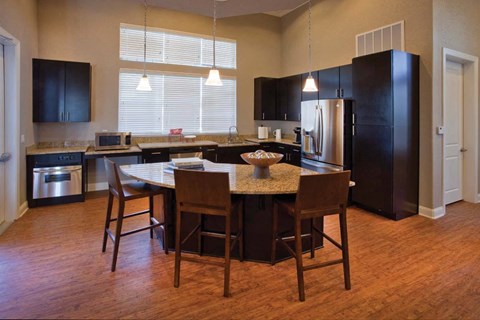 a kitchen with a large island and a table with chairs