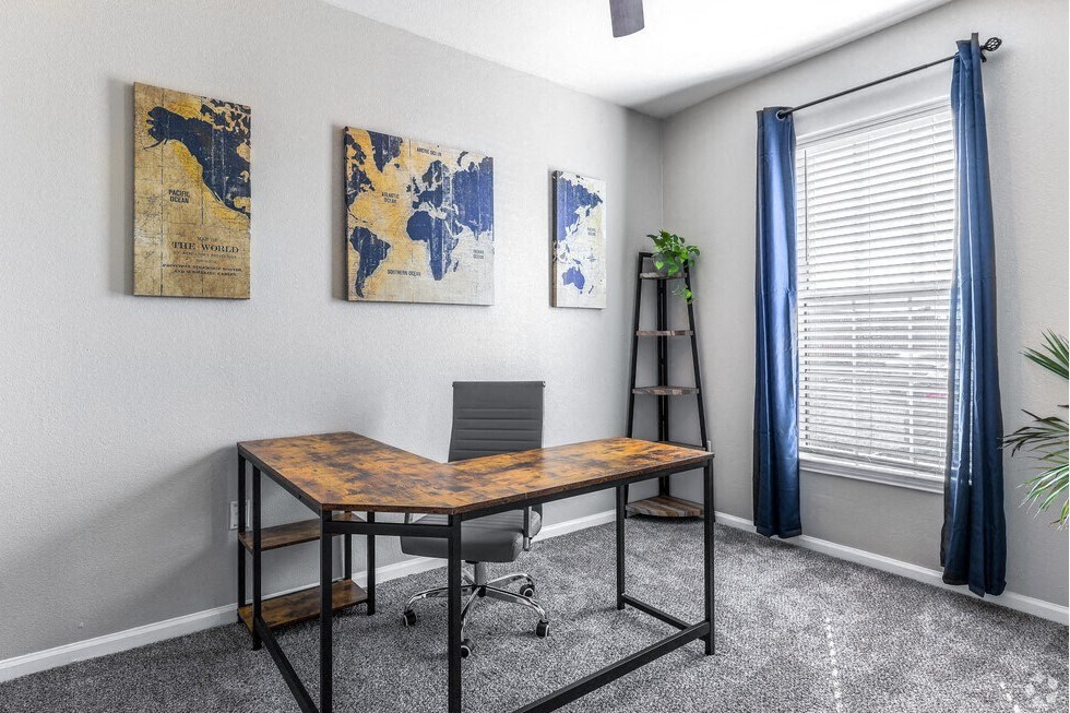 an office with a desk and a window with a blue curtain