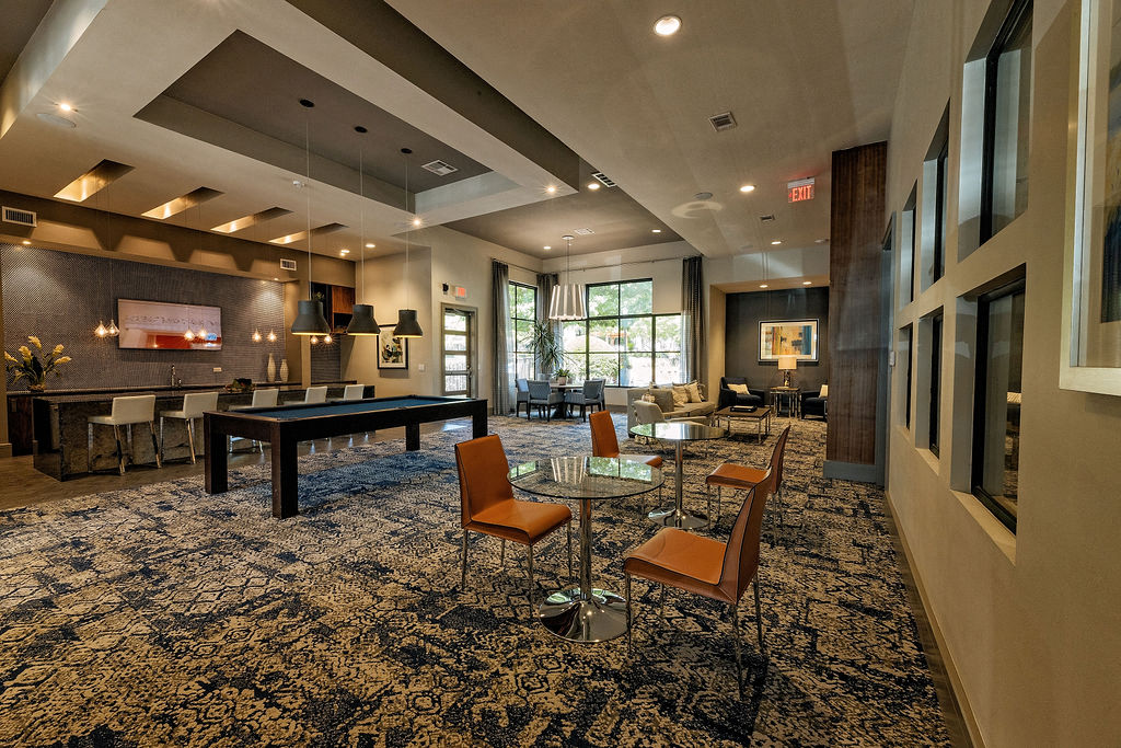 A large room with a pool table and chairs.