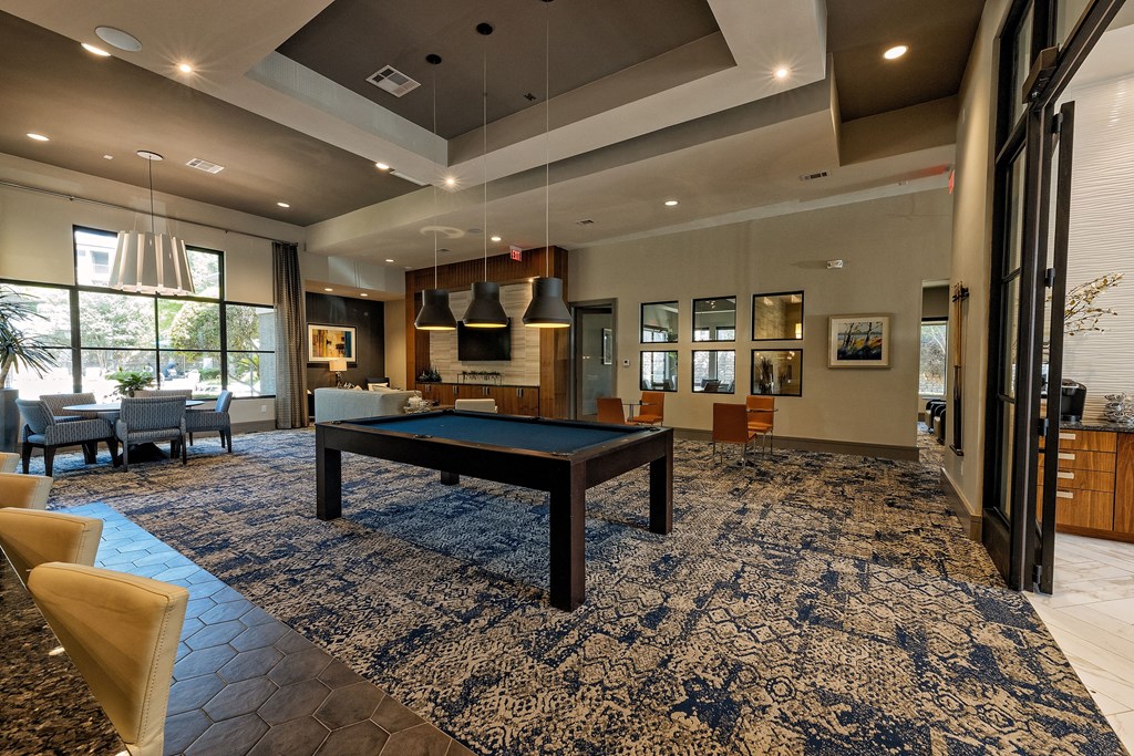 a spacious clubhouse with a pool table in the center