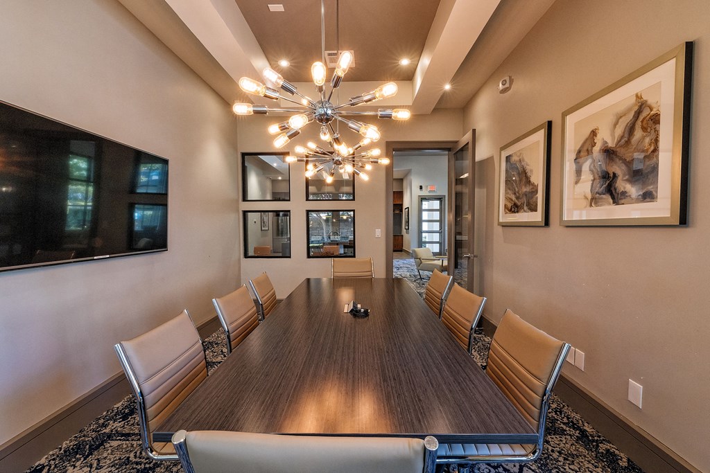 a conference room with a large table and chairs under a chandelier