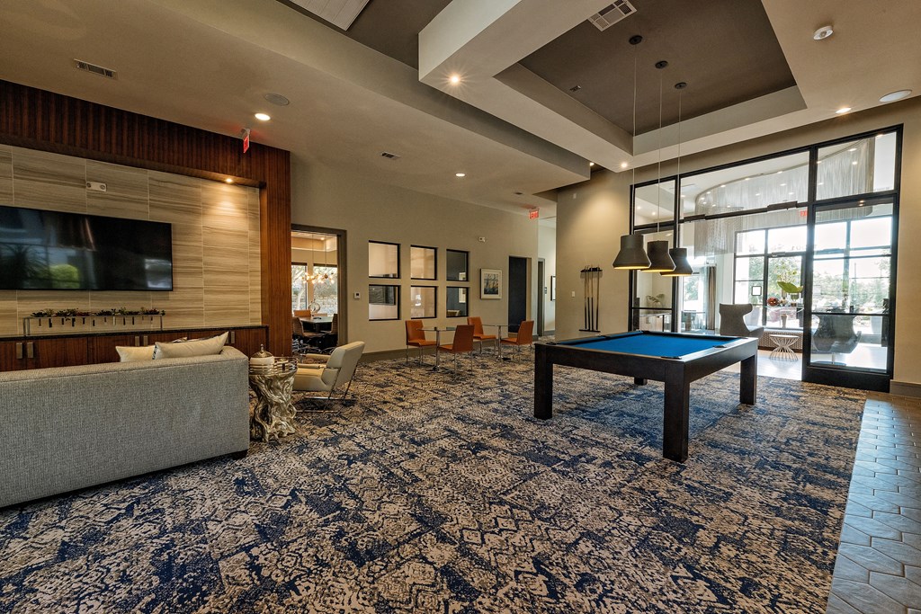 a lounge area with a pool table and a television