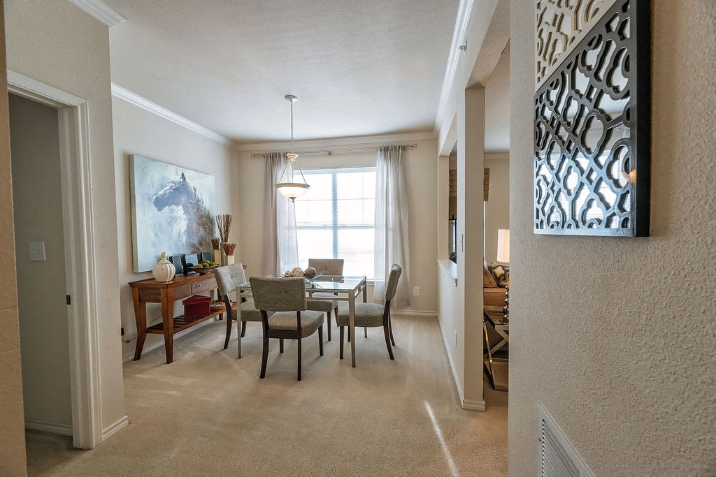 A dining room with a table and chairs.
