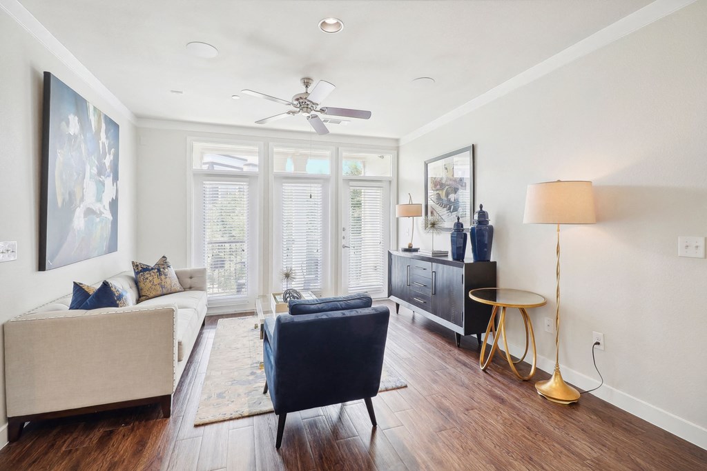 a living room with a couch and a chair and a ceiling fan