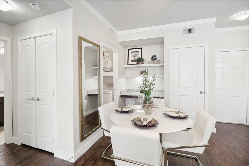 a dining room with a white table and chairs
