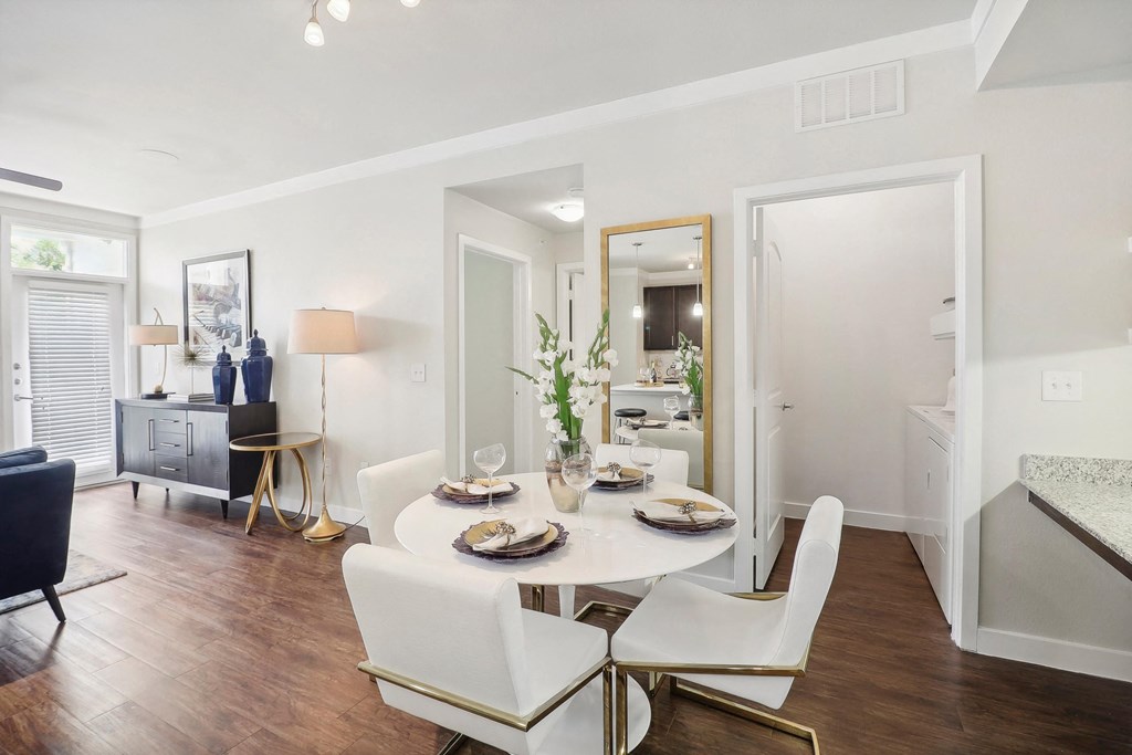 a living room and dining room with a table and chairs