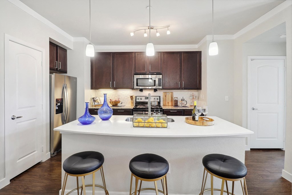 a kitchen with a large island with three stools