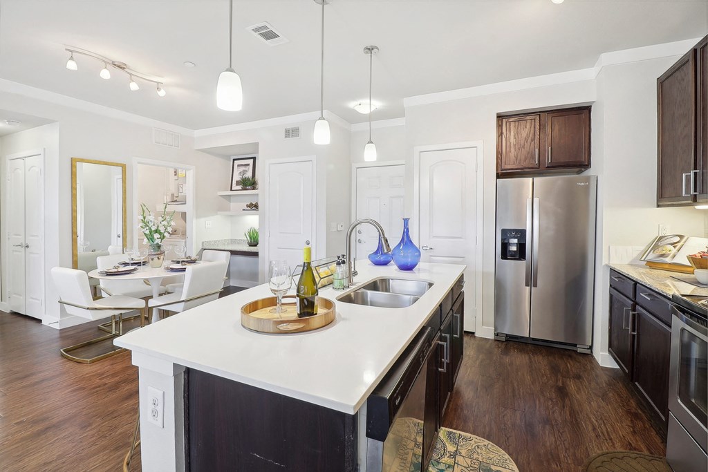 a kitchen with a large island and a stainless steel refrigerator