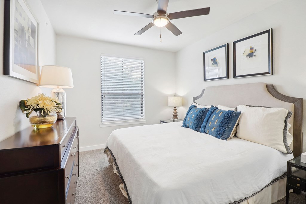 a bedroom with a large bed and a ceiling fan