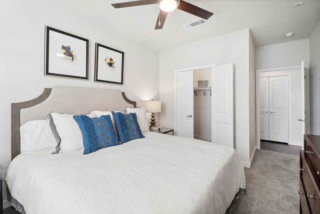 a bedroom with a large bed and a ceiling fan