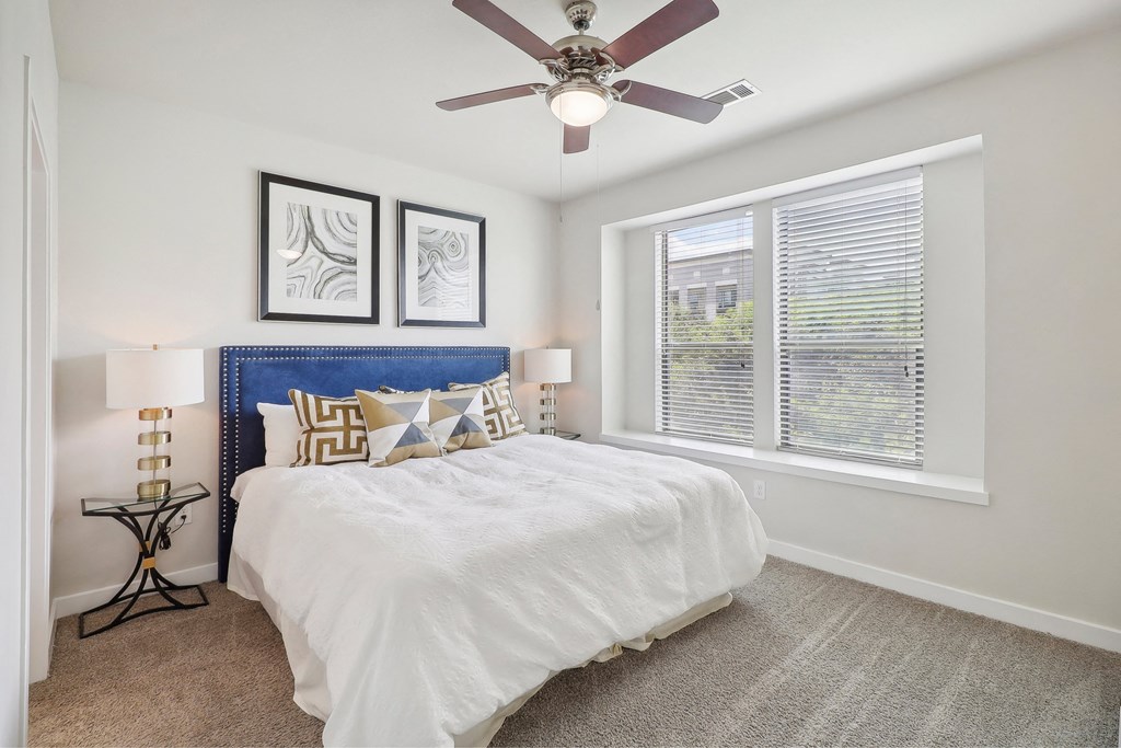 a bedroom with a bed and a ceiling fan