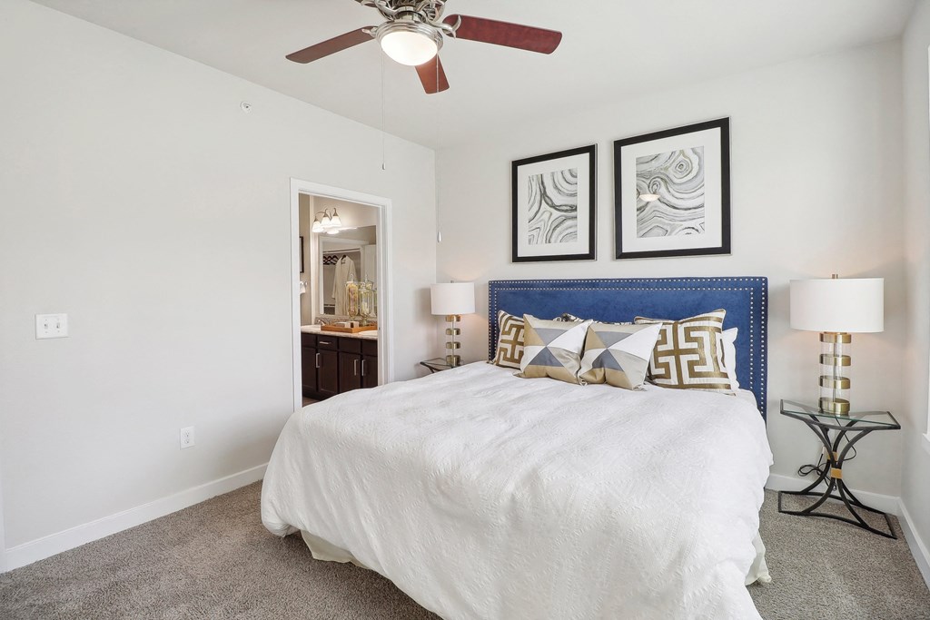 a bedroom with a large bed and a ceiling fan