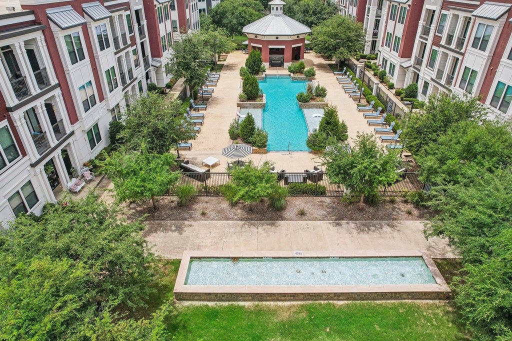 an aerial view of the pool and courtyard of an apartment building