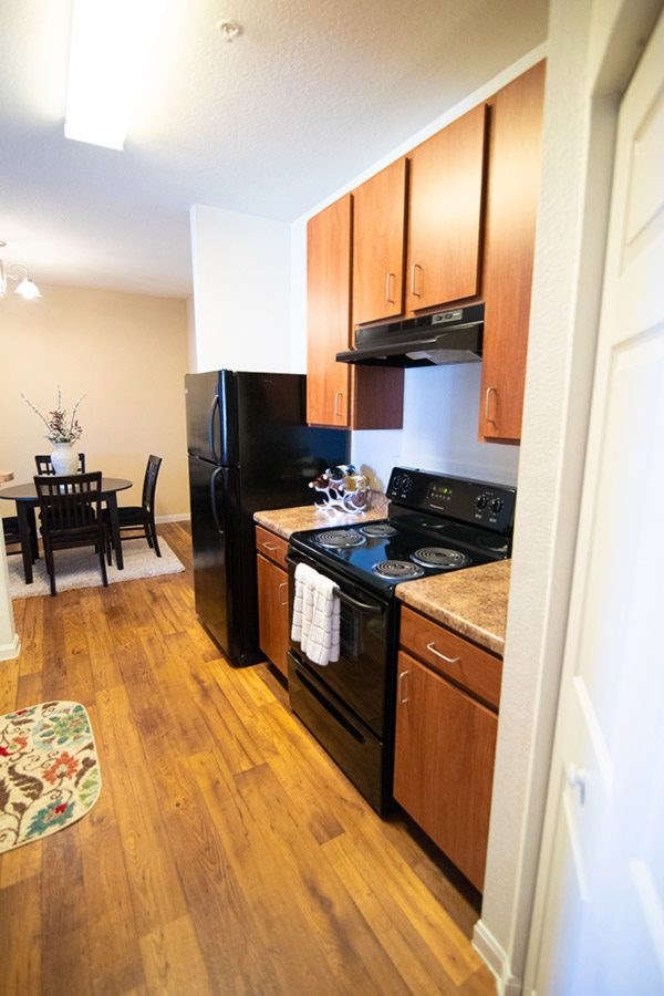 A kitchen with wooden cabinets and black appliances.
