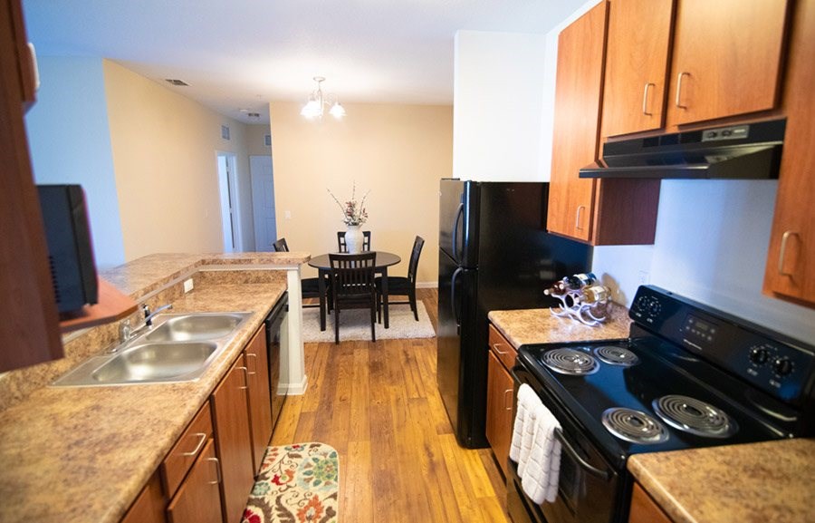 A kitchen with wooden cabinets and a black stove top oven.