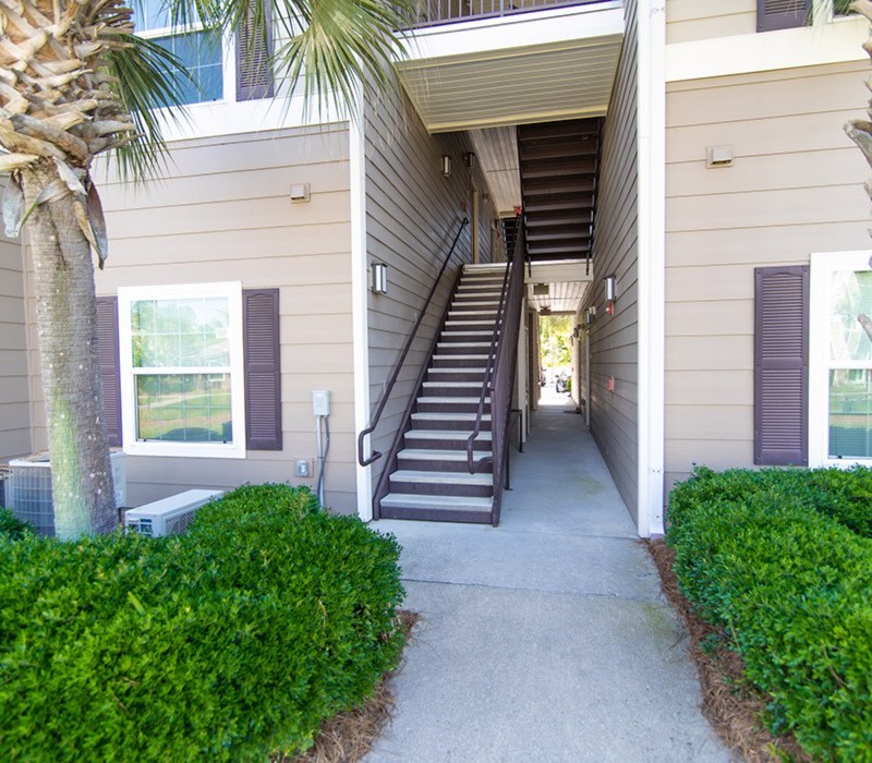 A concrete staircase leads to a doorway between two buildings.
