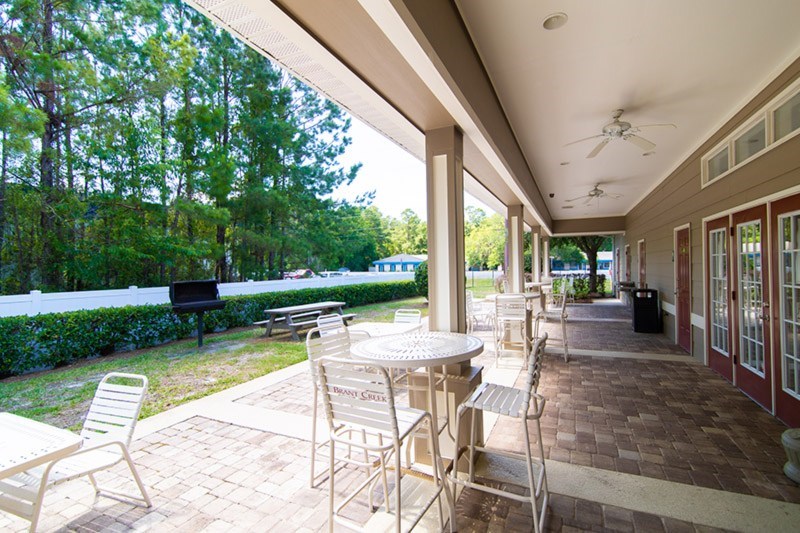 A patio with a table and chairs is covered by a roof.