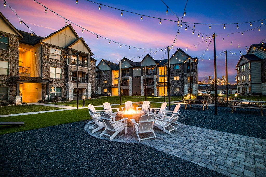 a patio with a fire pit and chairs at the enclave at woodbridge apartments in sugar land