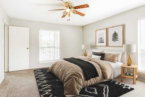 A bedroom with a large bed and a ceiling fan.