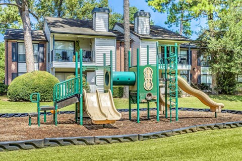 A playground with a green slide and a yellow slide.