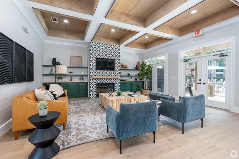 A living room with a yellow sofa, a grey armchair, and a black table.