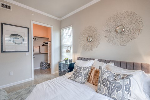 A bedroom with a large bed and a painting on the wall.