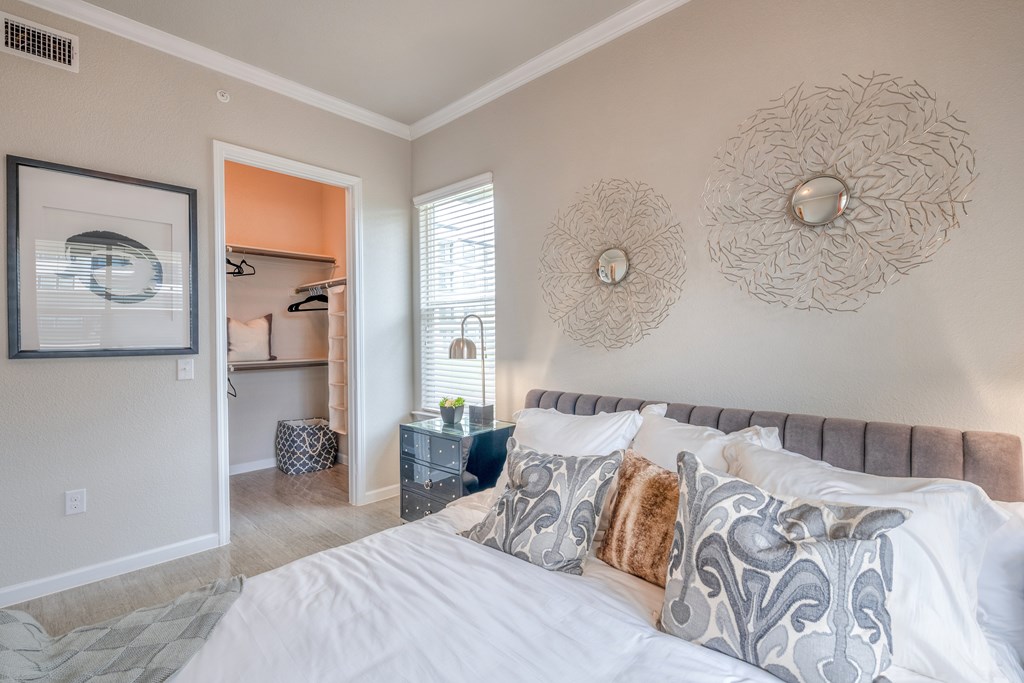 A bedroom with a large bed and a painting on the wall.