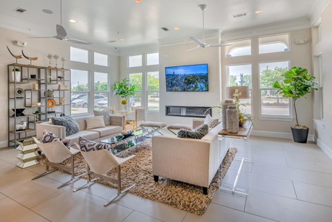 A living room with a white couch and a television on the wall.