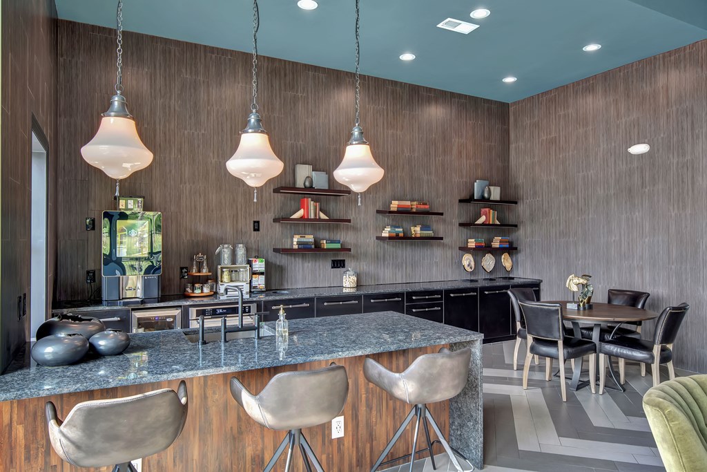 a kitchen with a large island with a breakfast bar and a dining area in the background