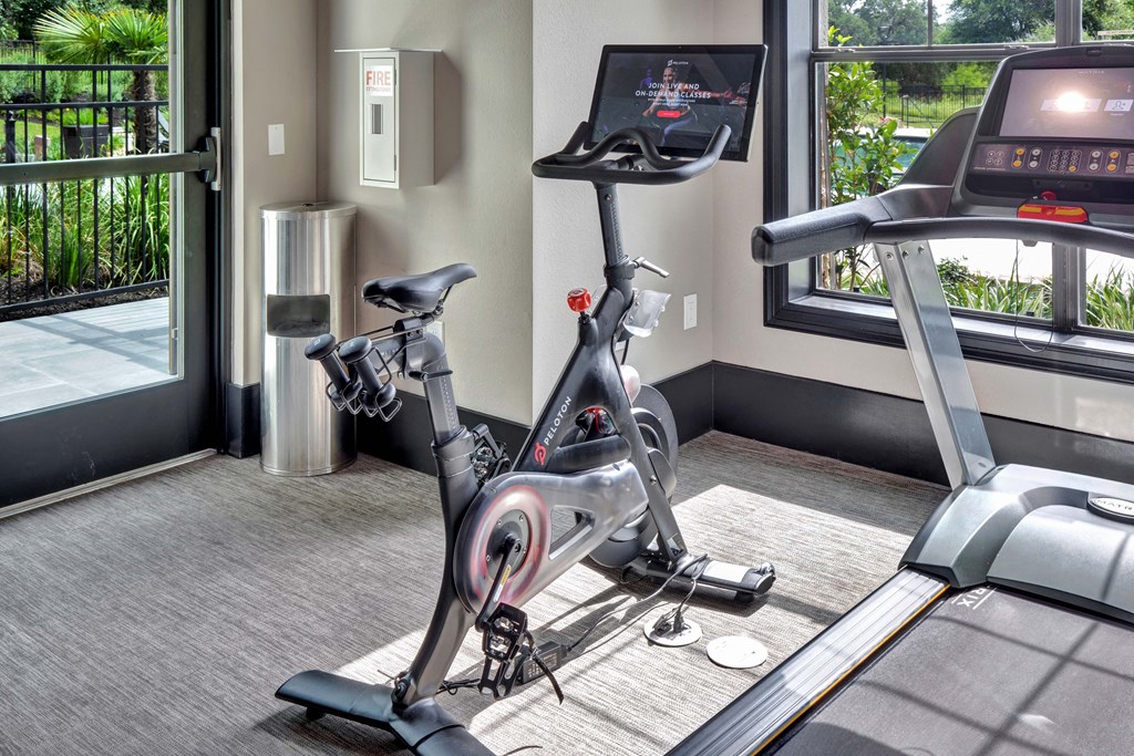 a treadmill and exercise bike in the fitness room