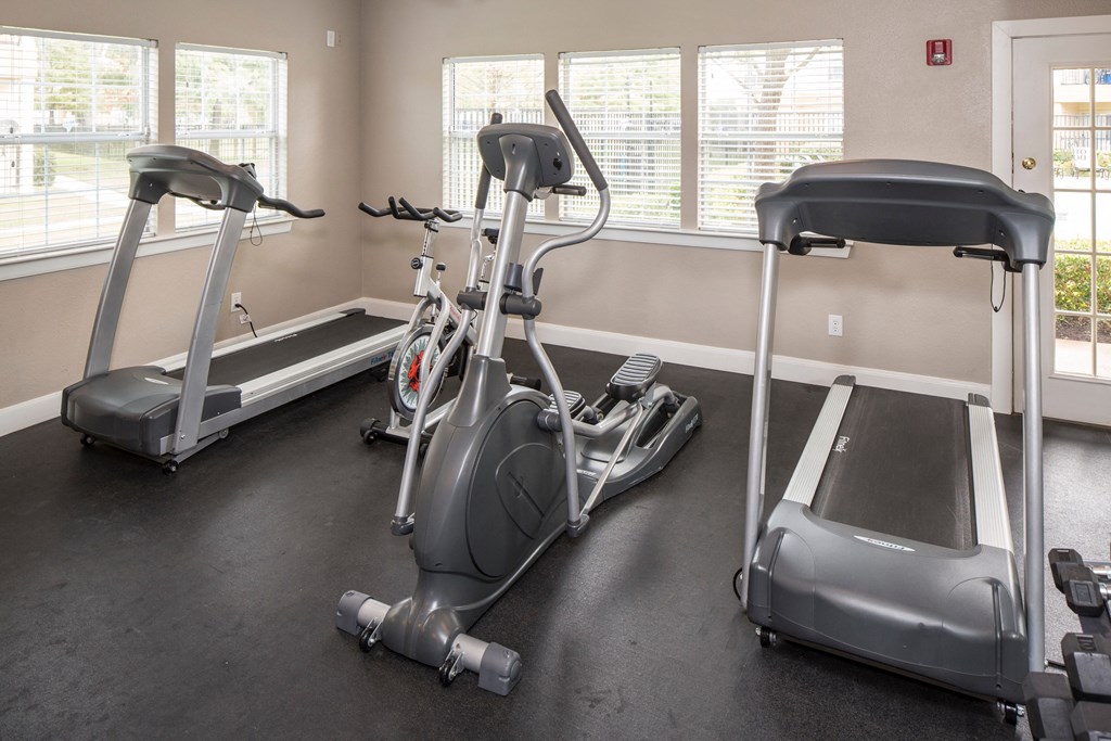 a home gym with a treadmill and elliptical