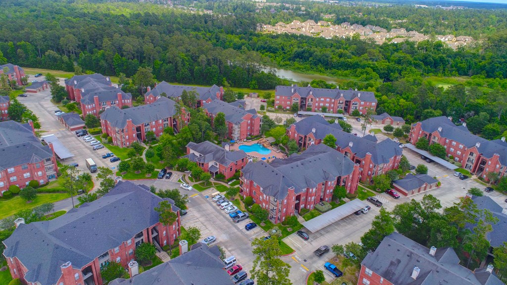 arial view of a large brick housing complex with a blue pool in the middle of the