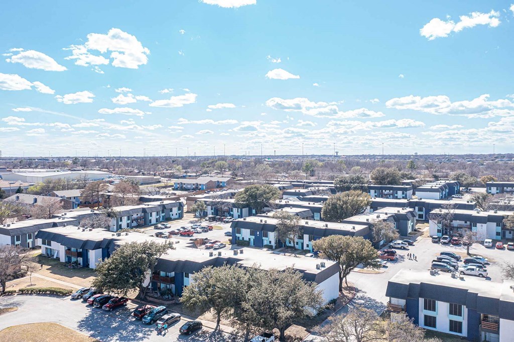 an aerial view of a city with houses and cars