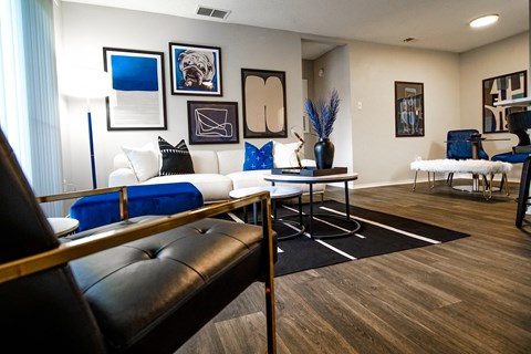 A living room with a white couch and a black leather chair.