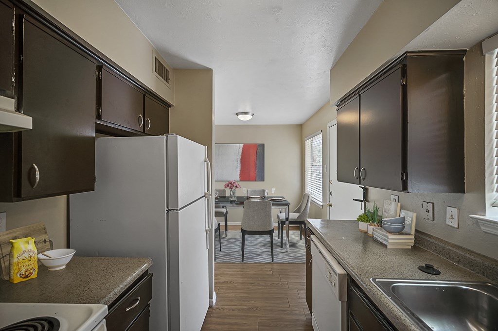 an open kitchen and dining room with stainless steel appliances and countertops