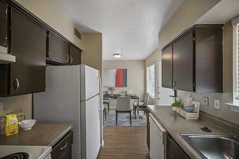 an open kitchen and dining room with stainless steel appliances and countertops