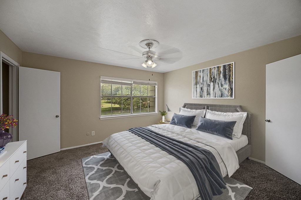 a bedroom with a bed and a ceiling fan