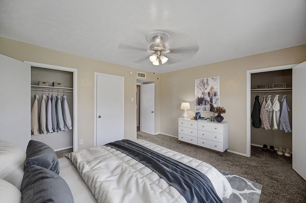 a bedroom with a bed and closet and a ceiling fan
